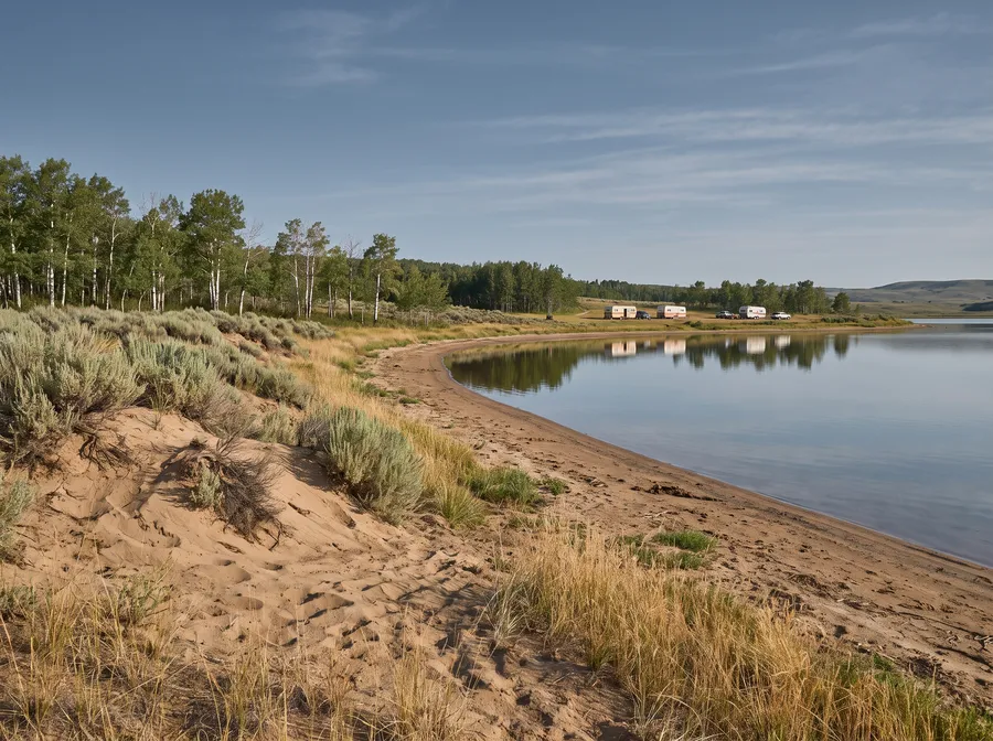 Prairie lake with a sandy shore and trailers